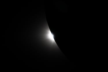 El Sol comienza a asomar por detrás de la Luna, visto desde la nave espacial Orión cerca del final del sobrevuelo lunar Artemis II. 