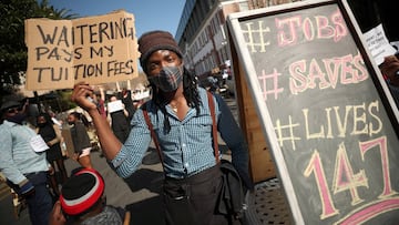 FILE PHOTO: A restaurant worker holds a placard during a protest against the coronavirus disease (COVID-19) restrictions in Cape Town, South Africa, July 22, 2020. REUTERS/Mike Hutchings/File Photo