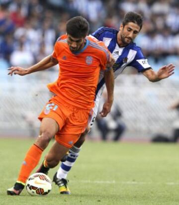 El centrocampista del Valencia André Gomes (i) con el balón perseguido por el centrocampista de la Real Sociedad Markel Bergara (d), durante el partido de la sexta jornada de Liga de Primera División disputado esta tarde en el estadio de Anoeta.