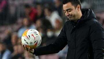 Barcelona's Spanish coach Xavi holds a ball during the Spanish League football match between FC Barcelona and Cadiz CF at the Camp Nou stadium in Barcelona on April 18, 2022. (Photo by LLUIS GENE / AFP)
