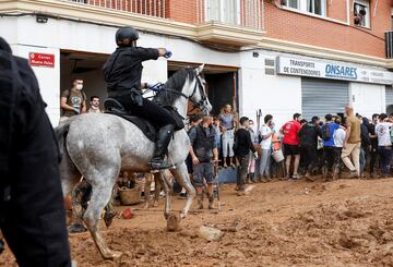 Un miembro de la Guardia Civil española patrulla a caballo mientras la gente protesta durante la visita del rey Felipe VI a Paiporta, Valencia.