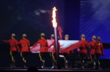 The torch is seen as Canadian mounties carry the national flag during the opening ceremony for the 2015 Pan American Games at the Rogers Centre in Toronto, Ontario, on July 10, 2015.    AFP PHOTO / HECTOR RETAMAL