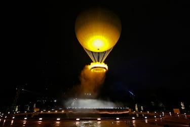Teddy Riner y Marie-Jose Perec encienden la llama olmpica y observan como se eleva el pebetero en un globo.
