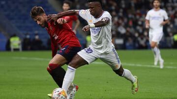 GRAF1321. MADRID, 27/10/2021.- El delantero brasileño del Real Madrid, Vinicius Junior (d) pelea un balón con el defensa de Osasuna Nacho Vidal, durante el partido entre Real Madrid y Osasuna, de LaLiga, que se disputa este miércoles en el estadio Santiag