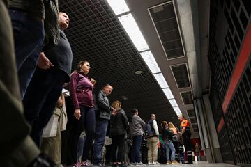 La gente espera a que se abran las puertas de una estación de metro mientras las operaciones del metro se reanudan parcialmente.