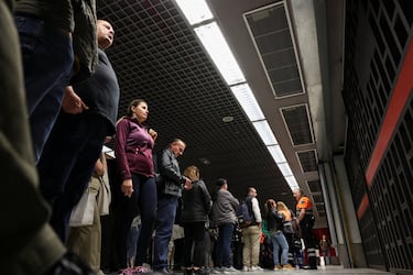 La gente espera a que se abran las puertas de una estación de metro mientras las operaciones del metro se reanudan parcialmente.