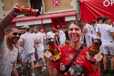 Los juerguistas beben vino de sacos de cuero mientras llenan la plaza principal durante el inicio oficial de nueve días de fiesta ininterrumpida en el famoso festival de encierros de toros de Pamplona.