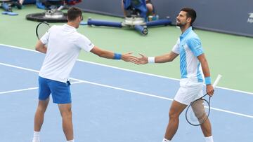 Novak Djokovic choca manos con su compañero de dobles, Cacic, en Cincinnati.