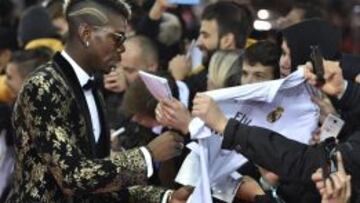 El ‘todocampista’ francés de la Juve sorprendió en la Gala del Balón de Oro con una chaqueta de esmoquin azabache y oro. Brilló tanto como el trofeo de Messi. Pogba también llamó la atención por sus pendientes de diamantes, su atrevido corte de pelo y sus gafas. Fue con su madre. Un look Galáctico con el que firmó una camiseta del Real Madrid.