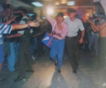 Juan Carlos Ibáñez abrazado por un carabinero, en la llegada desde El Salvador a la capital.