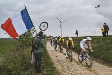 El grupo de ciclistas pedalea en una zona pavimentada durante la 122.ª edición de la clásica carrera ciclista de un día París-Roubaix.