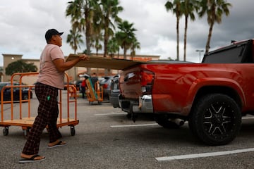 Un hombre compra madera para proteger su casa ante la llegada del huracán Milton, en Orlando.