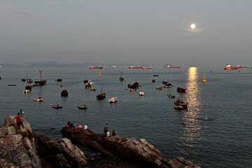 La luna llena aparece en el cielo nocturno sobre una bahía durante las vacaciones del Festival del Medio Otoño el 17 de septiembre de 2024 en Dalian, provincia de Liaoning, China.