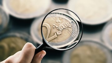 A magnifying glass focusing on 2 euro coins