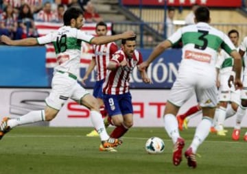 GRA172. MADRID, 18/04/2014.- El delantero del Atl¨¦tico de Madrid David Villa (c) controla el bal¨®n ante los jugadores del Elche, Sergio Pelegr¨ªn (i) y Alberto Tom¨¢s Bot¨ªa, durante el partido de la jornada 34 de liga en primera divisi¨®n disputado esta noche en el estadio Vicente Calder¨®n. EFE/Paco Campos
