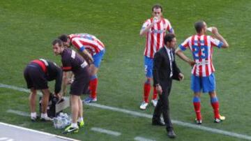 Varios jugadores del Atl&eacute;tico de Madrid se refrescan debido a las altas temperaturas que se registraron durante el partido.