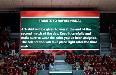 Una pantalla gigante muestra un mensaje para los espectadores para el homenaje a Rafa Nadal. El mensaje dice: "Homenaje a Rafael Nadal. 
Se te entregará una camiseta al finalizar el segundo partido del día. Cuídala y asegúrate de llevar el color que te corresponde. La celebración tendrá lugar justo después del tercer partido".

