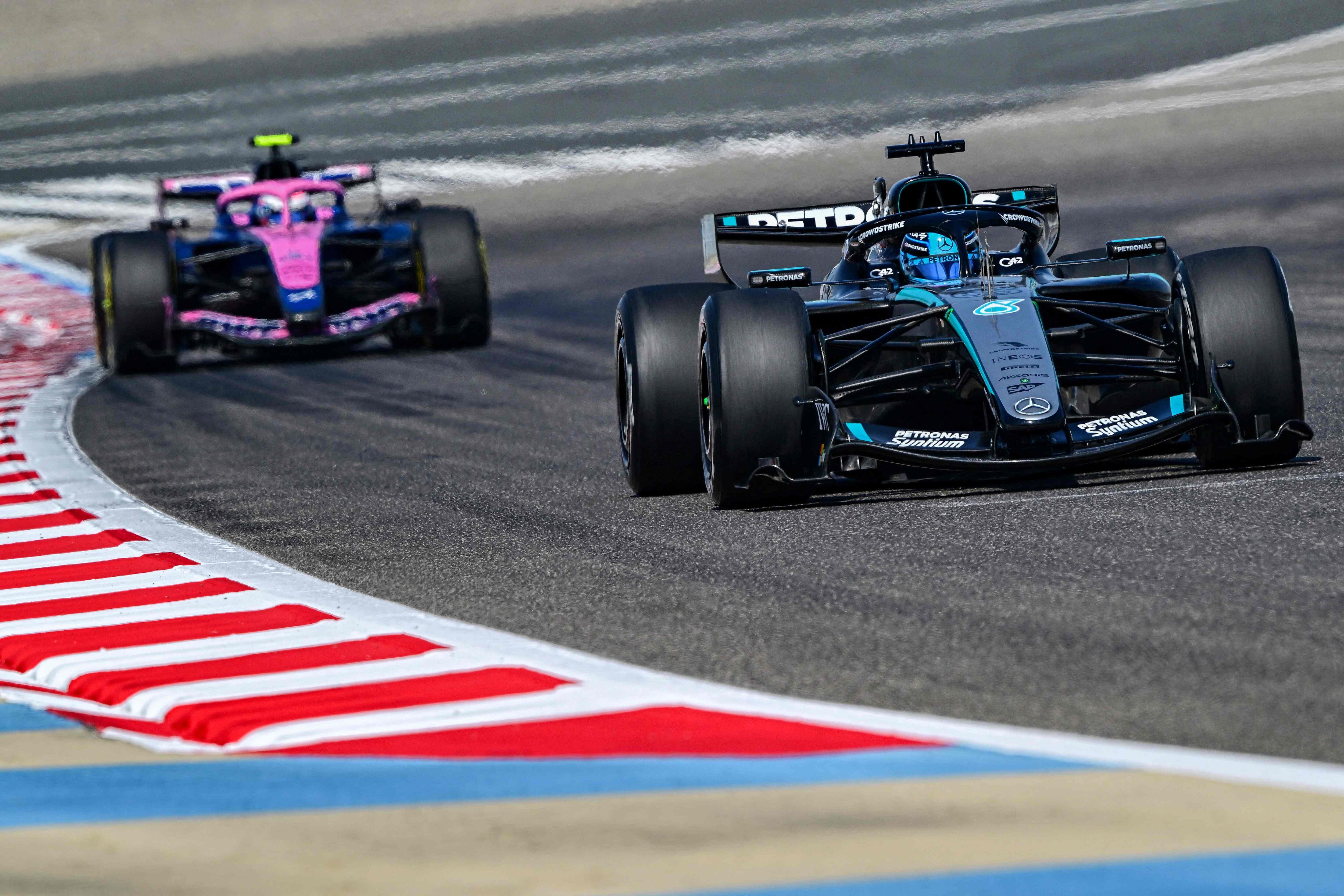 Mercedes' British driver George Russell drives ahead of Alpine's Argentine driver Franco Colapinto on the third day of the Formula One pre-season testing at the Bahrain International Circuit in Sakhir on February 13, 2026. (Photo by Giuseppe CACACE / AFP)