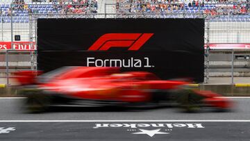 El piloto de Ferrari, Sebastian Vettel, pasa por delante del logo de la competición con su monoplaza. 