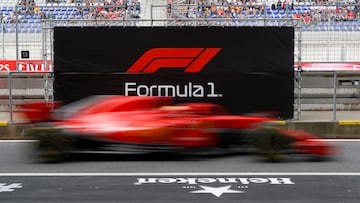 El piloto de Ferrari, Sebastian Vettel, pasa por delante del logo de la competición con su monoplaza. 