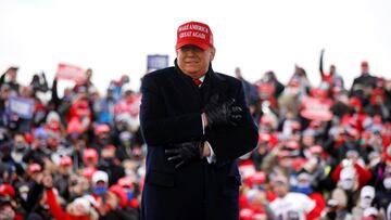 Donald Trump reacts to cold weather and wind during a campaign rally at Michigan Sports Stars Park in Washington, Michigan.