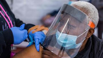 Registered Nurse Ebony Thomas (L) administers a Moderna Covid-19 vaccine to Stella Onwytalu, 89, at Kedren Community Health Center, in South Central Los Angeles, California on February 16, 2021. (Photo by Apu GOMES / AFP)