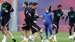 Leo Messi toca el nuevo bal&oacute;n de la Champions League durante el entrenamiento de ayer.