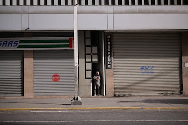 Un hombre se encuentra entre tiendas cerradas, la mañana después de que Estados Unidos atacase a Venezuela.