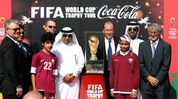 FILE PHOTO: Qatar Football Association general secretary Saoud Al-Mohannadi (5th L), FIFA representative Gabriel Calderon of Argentina (4th R) and soccer coach Bora Milutinovic (R) pose with others next to the FIFA World Cup trophy following its arrival i