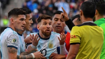 Argentina's Lionel Messi (C) talsk to Paraguayan referee Mario Diaz de Vivar after he and Chile's Gary Medel (out of frame) were sent off during their Copa America football tournament third-place match at the Corinthians Arena in Sao Paulo, Braz