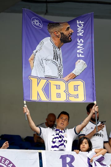 A Real Madrid fan displays a large banner with the image of Benzema.