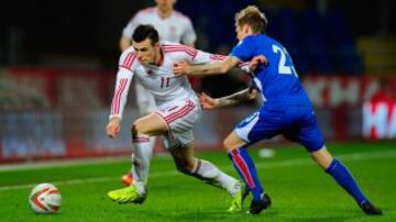 Gareth Bale compite con Ari Freyr Skulason de Islandia durante el partido amistoso entre Gales e Islandia en el estadio Cardiff City