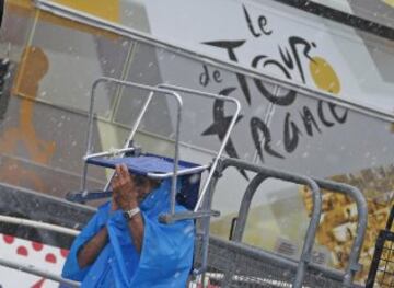 Un espectador se protege de la lluvia con una silla en la cabeza.