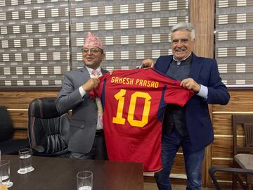 El presidente del Senado de Nepal, sonriente junto a la camiseta de La Roja que el Cacereño le ha regalado.