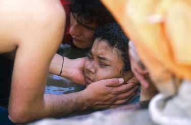 Un rescatista ayuda a un niño atrapado en un lahar proveniente del volcán Nevado del Ruiz, en Colombia.