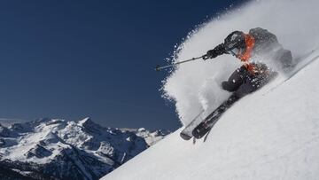 El esquiador Aymar Navarro esquiando sobre nieve virgen en Baqueira Beret (Val d'Aran, Lleida, Catalunya, España) con las montañas al fondo.
