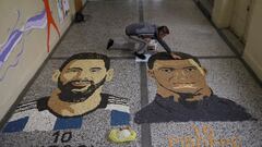 Kosovar artist Alkent Pozhegu works on the last details of his mosaic, made with grain and seeds on the ground, depicting Argentina's soccer player Lionel Messi and France's soccer player Kylian Mbappe in Gjakova, Kosovo, December 18, 2022. REUTERS/Fatos Bytyci