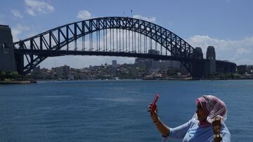 A sightseer poses for a selfie in front of the Sydney Harbour Bridge in the wake of coronavirus disease (COVID-19) regulations easing, following months of lockdown orders to curb an outbreak, in Sydney, Australia, October 19, 2021. REUTERS/Loren Elliott