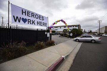 Norwalk (United States), 12/04/2020.- A cars drives in the parking lot under a large banner reading 'Heroes Work Here' during a drive-in Easter mass at the New Harvest Church amid the coronavirus pandemic in Norwalk, south of Los Angeles, California, USA,