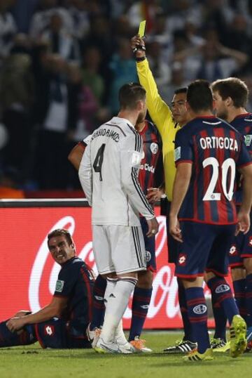 El defensa del Real Madrid Sergio Ramos (2-i) recibe la tarjeta amarilla, durante la final del Mundial de Clubes ante San Lorenzo que están disputando esta noche en el Gran Estadio de Marrakech, en Marruecos. 