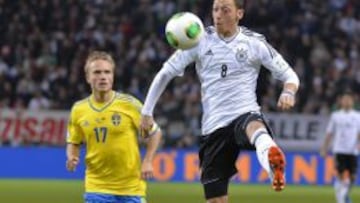 El jugador de Alemania, Mesut Oezil, disputa un bal&oacute;n contra el jugador de Suecia Pierre Bengtsson hoy, martes 15 de octubre de 2013, durante un partido contra Alemania para clasificar al Mundial de Brasil 2014 en el Friends Arena en Estocolmo (Suecia). 