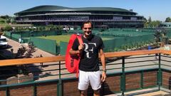 Roger Federer posa antes un entrenamiento con la pista central de Wimbledon de fondo.