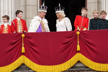 Los reyes, con sus coronas especiales para el día de la coronación, hablan entre ellos en el balcón principal del Palacio de Buckingham.