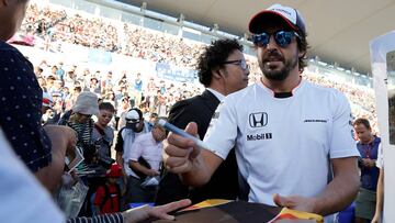 Fernando Alonso firmando autógrafos a aficionados japoneses de McLaren Honda.