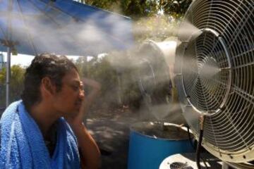 Un espectadores refrescandose durante los descansos para hacer frente a las temperaturas que llegan a 43 grados centígrados (109 Fahrenheit) durante el cuarto dia del Abierto de Australia 2014 en Melbourne Park