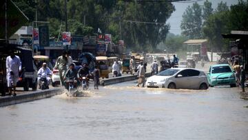 CHARSADDA, PAKISTAN - AUGUST 28: People try to leave the flooded areas after flash flood hit Charsadda district, in northwest, Khyber Pakhtunkhwa province, Pakistan on August 28, 2022. Record monsoon rains were causing a "catastrophe on large scale" as Pakistan has called for international assistance and help in dealing with floods that have killed more than 900 people since June. (Photo by Hussain Ali/Anadolu Agency via Getty Images)