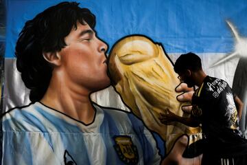Facundo Peralta, who works at Argentine flag painting business "Serigrafia del Oeste", paints a flag of Maradona.