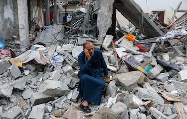 Un palestino se sienta sobre los escombros de un edificio destruido por los ataques israeles, en Rafah.