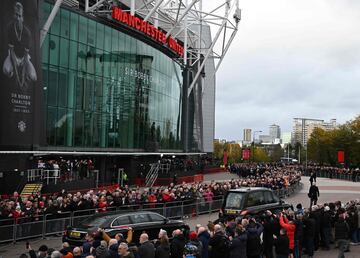 El coche fúnebre que transporta el ataúd de Bobby Charlton pasa por el estadio Old Trafford antes de su funeral.