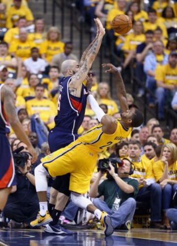 Pero Antic de los Atllanta Hawks ante  Paul George de los Indiana Pacers.